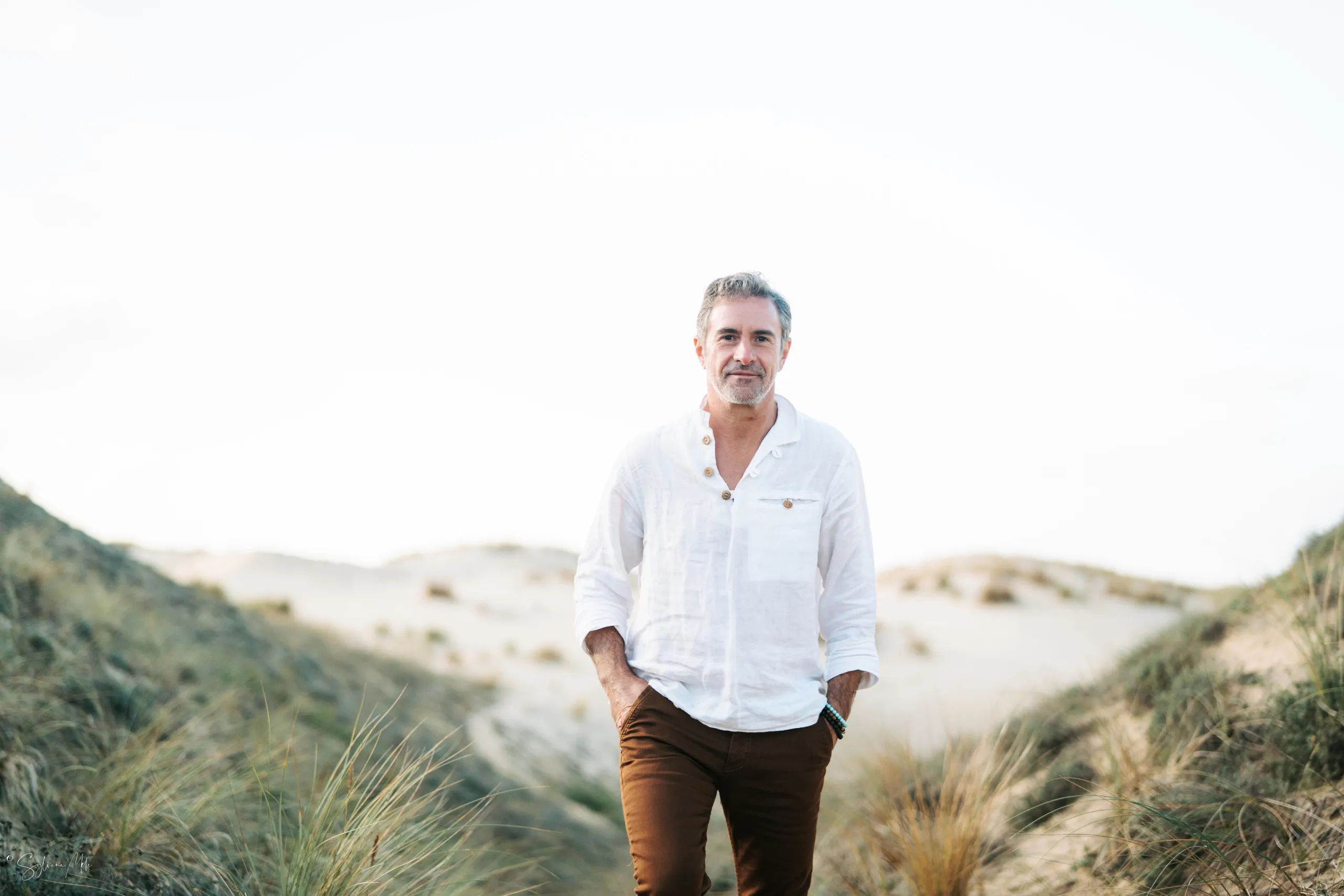 Pierre Lapoujade en chemise blanche sur une plage