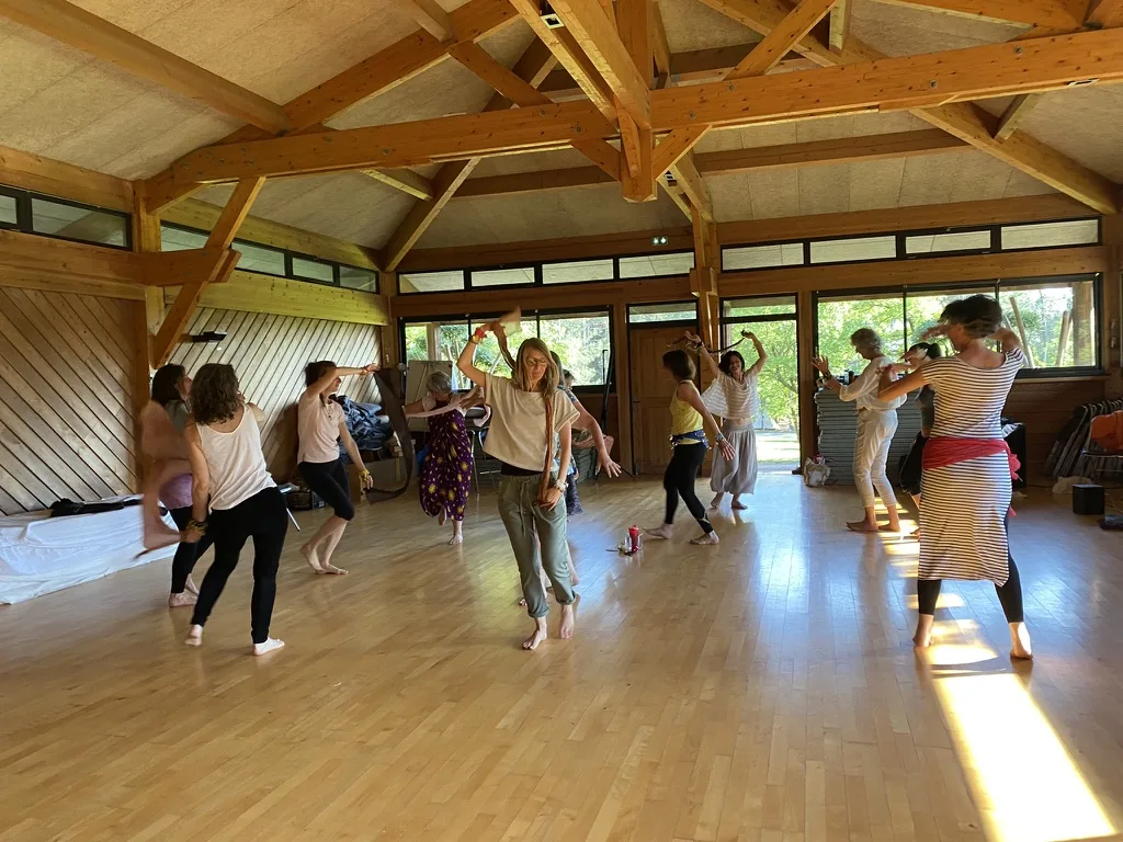 Participants en mouvement dans une salle en bois